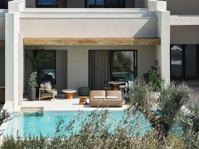 Espace extérieur moderne avec piscine, canapé et chaises dans un hôtel.