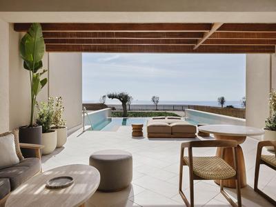 Espace extérieur moderne avec piscine, sièges et vue sur la mer