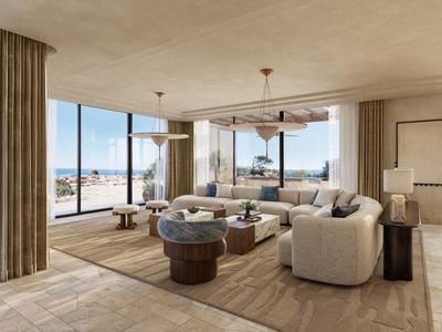 Salon spacieux avec grandes fenêtres donnant sur la mer dans une chambre d'hôtel.