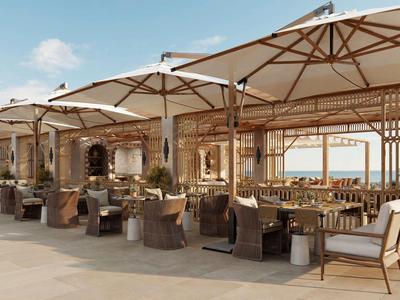 Terrasse extérieure d'hôtel avec parasols, tables et chaises sous un ciel clair