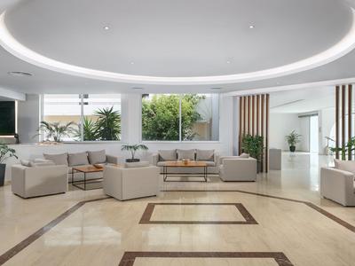 Jasna, nowoczesna lobby hotelowa z dużymi sofami i roślinami.