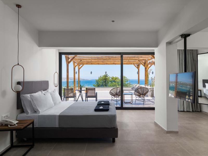 Nowoczesna sypialnia z dużym łóżkiem i widokiem na morze przez drzwi na taras