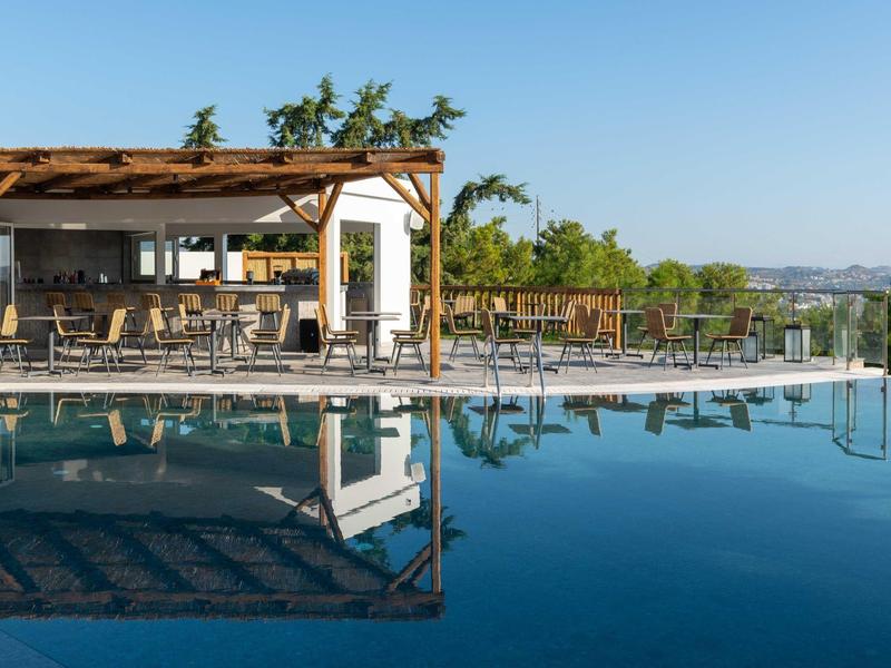 Nowoczesny basen z drewnianym pawilonem i leżakami w słonecznym krajobrazie