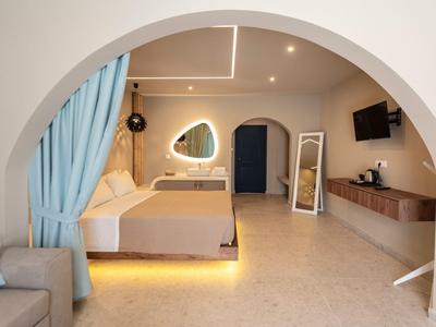 Helles Hotelzimmer mit großem Bogen, Doppelbett, Spiegel und modernem Design in Beige- und Blautönen.