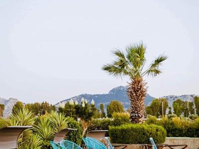 Due sdraio accanto a una piscina con palme e montagne sullo sfondo.