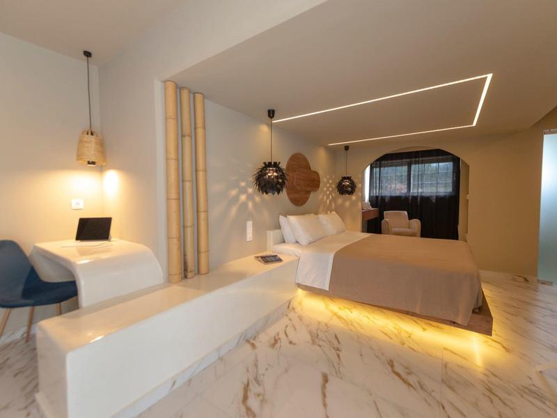 Camera d'hotel moderna con letto grande, illuminazione d'ambiente e mobili eleganti.