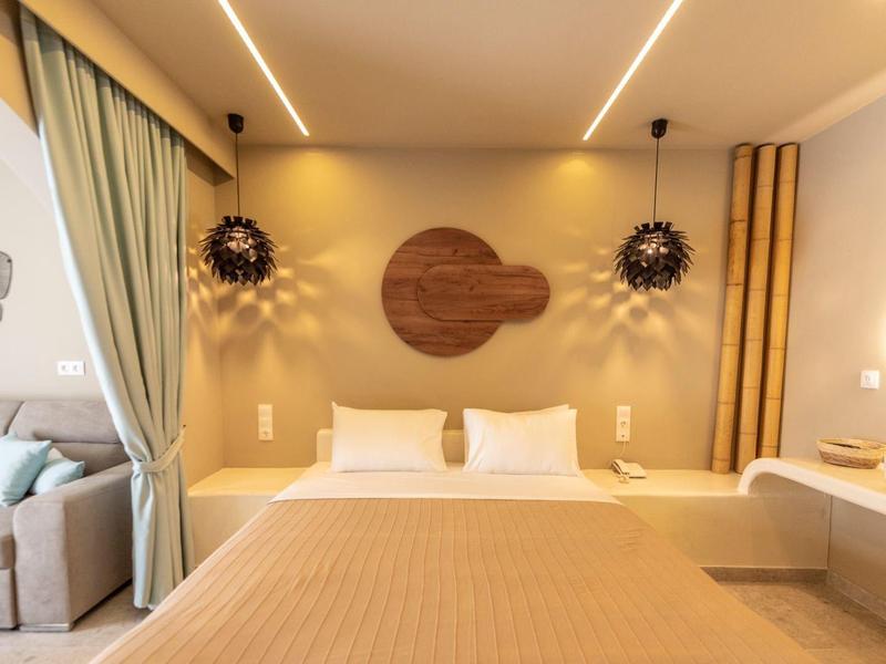 Camera d'hotel moderna con letto matrimoniale, tonalità calde e decorazioni murali eleganti.