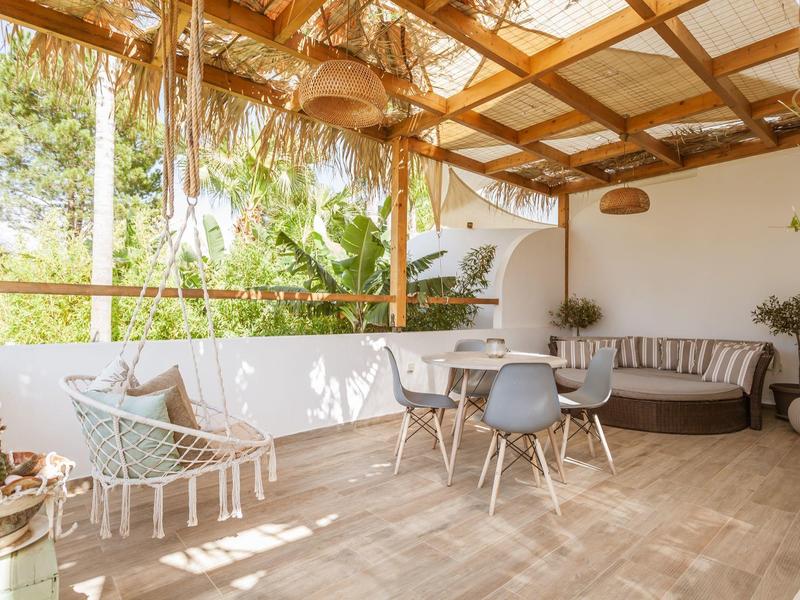 Accogliente patio coperto con amaca, area salotto e piante per rilassarsi.