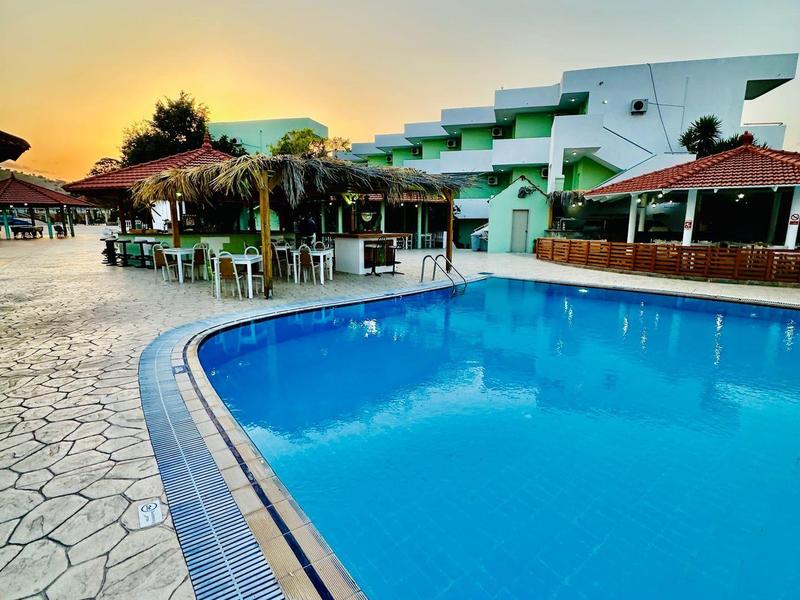 Piscina limpida davanti a un edificio moderno dell'hotel al tramonto.