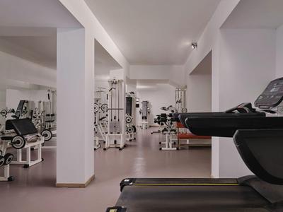 Moderner Fitnessraum mit Laufbändern und Kraftgeräten in hellem, offenem Raum.