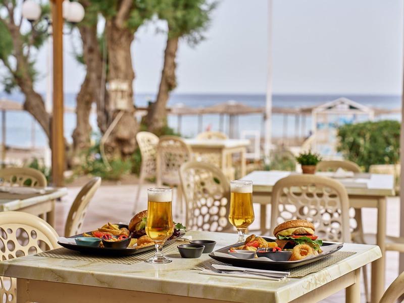 A set table with food and drinks on a terrace overlooking the sea.