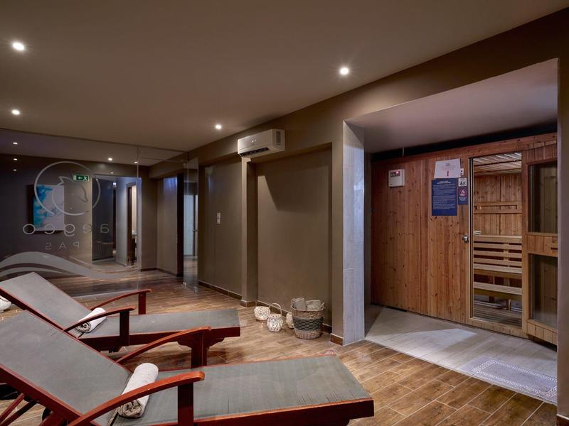 Relaxation room with lounge chairs and access to a sauna in a hotel.