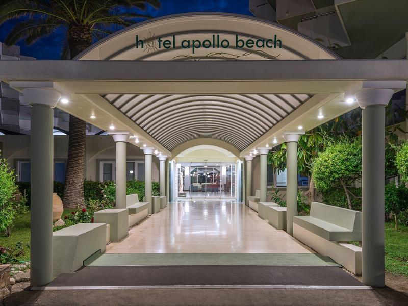 Osvětlená krytá chodba na pláži La Polla v noci s posezením a rostlinami.