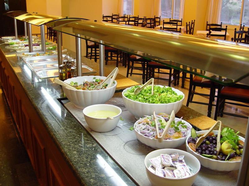 Moderní hotelový pokoj s pohodlnou postelí a výhledem na balkon a moře.