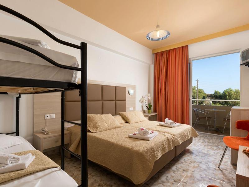 Zimmer mit Etagenbett, Doppelbett, Balkon, orangen Vorhängen und Fernseher an der Wand.