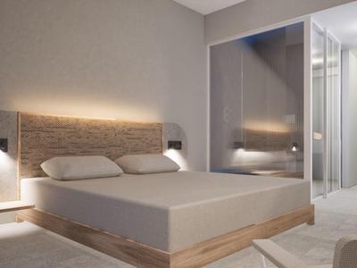 Modern bedroom with double bed, wall lighting, and spacious bathroom with glass wall.