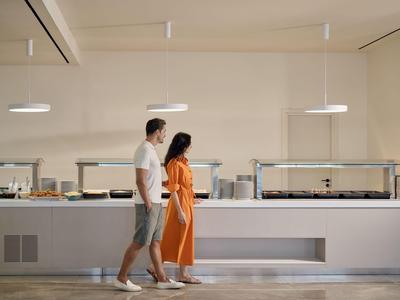 Coppia davanti a un buffet in una stanza luminosa e moderna.