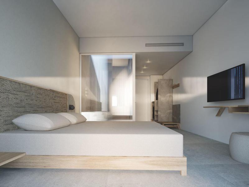 Modern hotel room with double bed, wall-mounted TV, and large glass shower in the background.