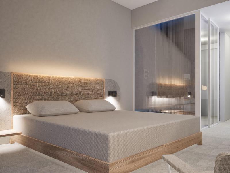 Modern bedroom with double bed, wall lighting, and spacious bathroom with glass wall.