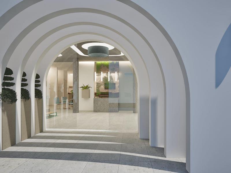 White arched passageway with plants along the sides in a modern building.