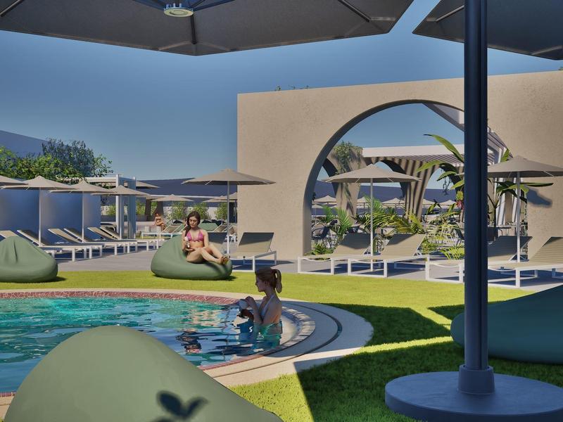 Modern outdoor pool area with lounge chairs and sun umbrellas under a blue sky.