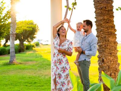 Young couple under a wooden pergola at sunset in the park.
