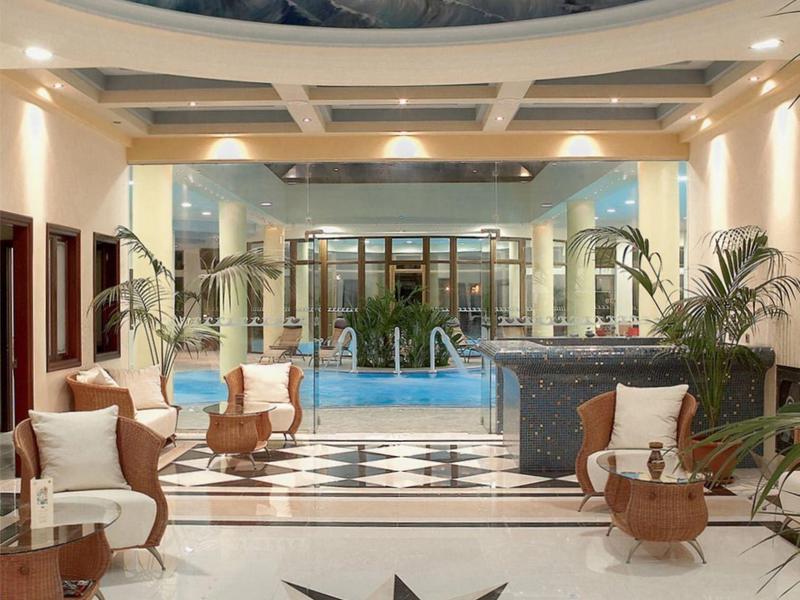 Luxusní vnitřní bazén s uměleckým stropem a pohodlným posezením.