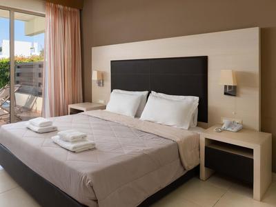 Camera d'hotel moderna con letto matrimoniale, comodini e balcone con vista esterna.