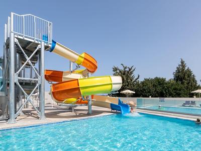 Scivoli d'acqua accanto a una piscina sotto un cielo azzurro.