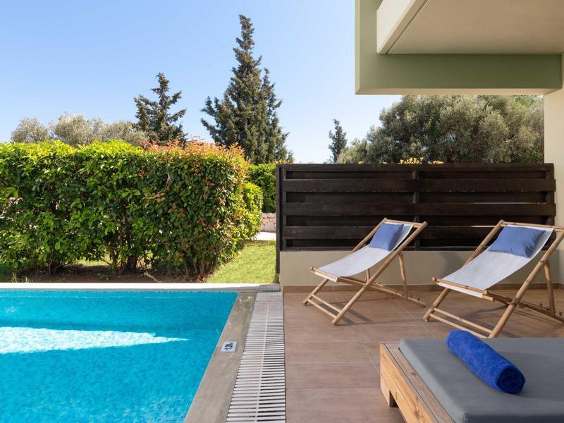 Area relax a bordo piscina con due sdraio e un asciugamano in una giornata di sole