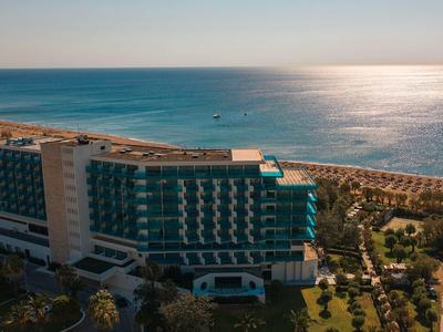 Edificio di un hotel moderno con vista mare e giardino ben curato sulla costa.