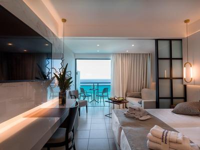 Camera d'hotel moderna con letto, scrivania, vista mare e balcone