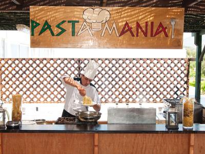 Kucharz przygotowuje makaron pod szyldem « PASTA MANIA » na otwartej przestrzeni.