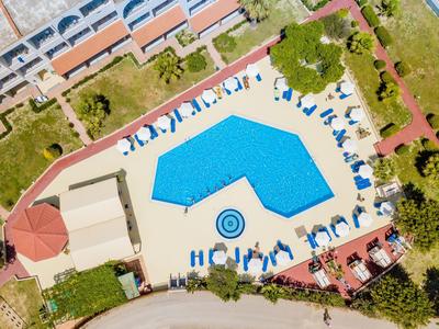 Widok z lotu ptaka na basen hotelowy z parasolami i leżakami na nasłonecznionym terenie