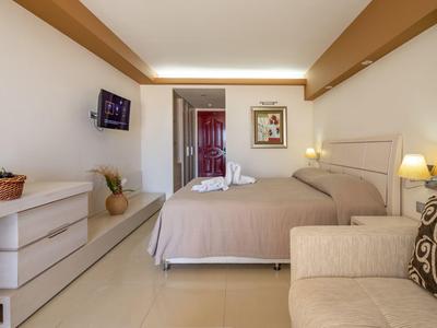 Open outdoor seating area with white furniture and sea view under clear sky.