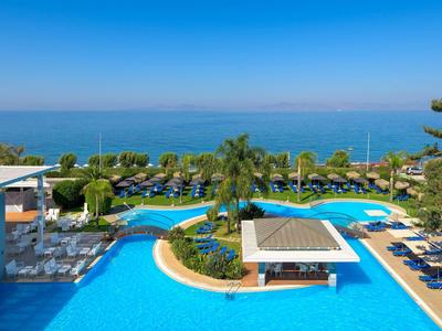 Großer Pool mit Bar in tropischem Hotelresort nahe Meer und Palmen.