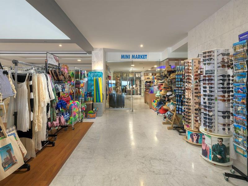 Interno di un piccolo negozio di souvenir ben fornito con abbigliamento e accessori in un hotel.