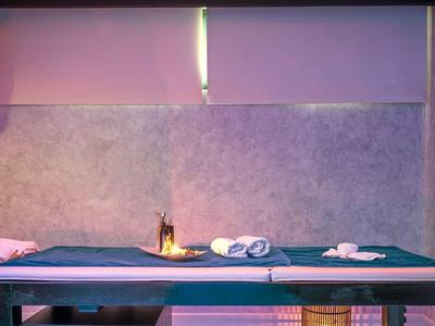 Lettino da massaggio in una stanza spa con illuminazione soffusa e decorazioni rilassanti.