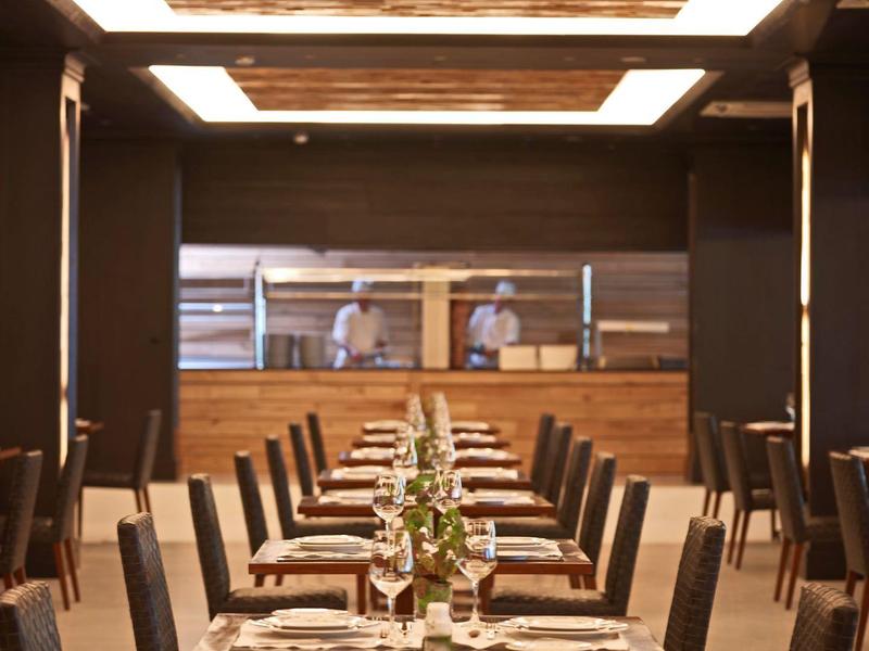 Sala da pranzo d'hotel elegante con tavoli allineati e decorazioni floreali.