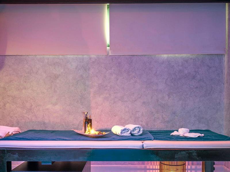 Lettino da massaggio in una stanza spa con illuminazione soffusa e decorazioni rilassanti.