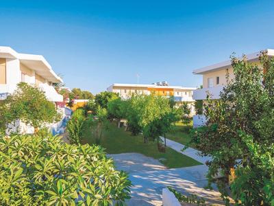 Residential buildings surrounded by well-kept greenery and walkways on a sunny day.