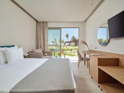 Chambre d'hôtel moderne avec lit double, bureau et vue sur le jardin.