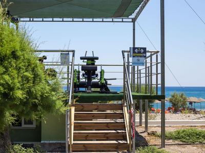 Eine Treppe führt zu einem Aussichtspunkt mit einem Fernglas in Strandnähe.