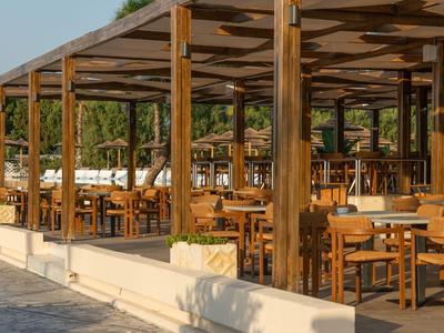 Überdachter Außenbereich mit Holzmöbeln eines Hotels oder Restaurants im Freien.
