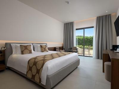 Modernes Hotelzimmer mit Doppelbett, TV, Balkon und minimalistischer Einrichtung.