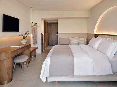 Modernes Hotelzimmer mit Doppelbett, Holzmöbeln und neutralen Farbtönen.