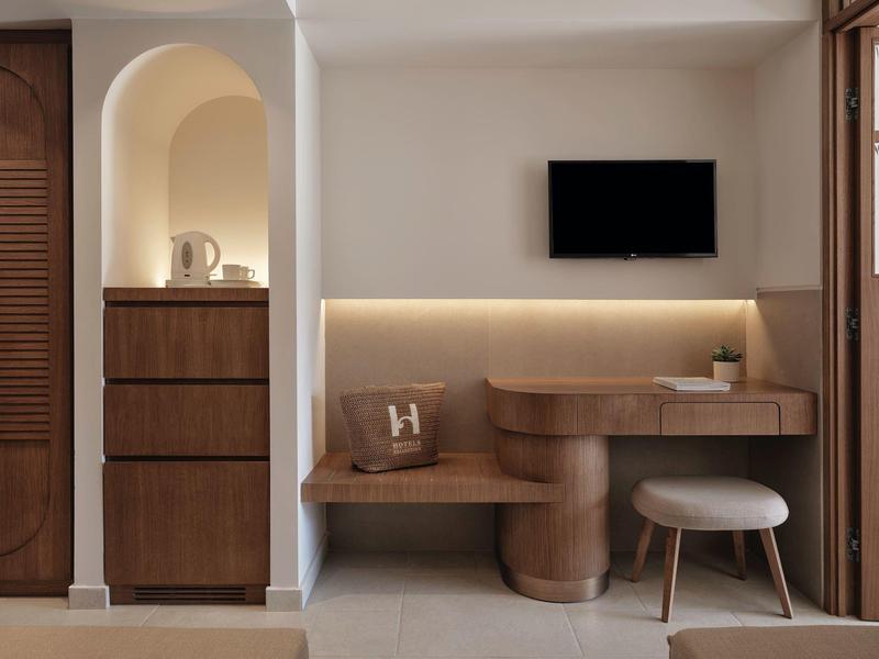 Area lavoro moderna in legno in camera d'hotel con TV.