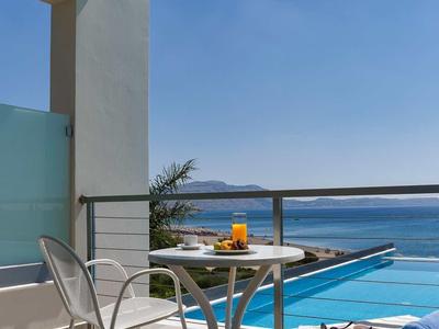 Balcone con sedie, tavolo e vista sull'oceano sotto un cielo sereno