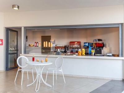 Banco bar moderno in hotel con tavolo e sedie bianche davanti