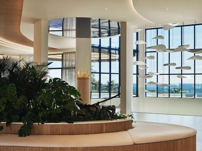 Moderner Hotellobbybereich mit großen Fenstern und gemütlichen Sitzgelegenheiten.